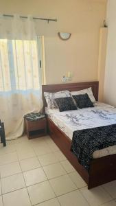 a bedroom with a bed and a window at Appartement - BIOKOU - Route des pêches in Cotonou