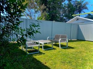 two chairs and a table in a yard at Little Red Brick House in Padstow