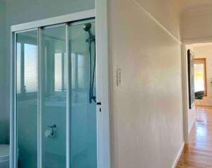 a glass shower door in a room with at Little Red Brick House in Padstow