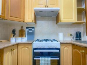 a kitchen with a stove and a white hood at Little Red Brick House in Padstow +5 photos