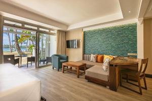 a hotel room with a couch and a table at Shandrani Beachcomber Resort & Spa in Blue Bay