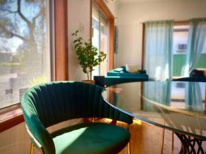 a glass table with a green chair in a room at Little Red Brick House in Padstow