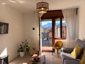 a living room with a couch and a large window at Itxinako Balkoia in Murueta-Orozko
