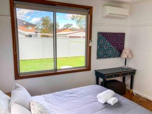 a bedroom with a bed and a desk with a window at Little Red Brick House in Padstow