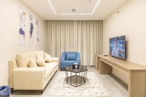 a living room with a couch and a blue chair at وساد الشمال للشقق الفندقية in Hail