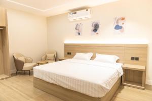 a bedroom with a large bed and two chairs at وساد الشمال للشقق الفندقية in Hail +17 photos