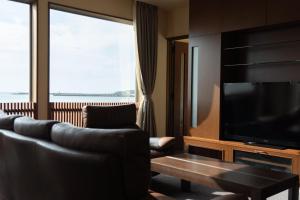 a living room with a couch and a flat screen tv at Kaitan稲佐の浜 in Taisha