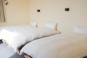 two beds sitting next to each other in a bedroom at Kaitan稲佐の浜 in Taisha