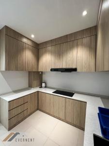 a kitchen with wooden cabinets and a stove at Suites Homestay by Evernent in Miri