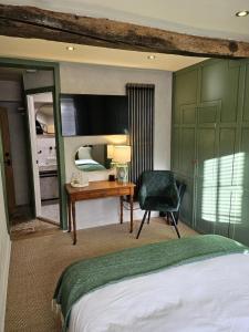 a bedroom with a bed and a desk and a chair at Cotswold Cottage Guest House in Stow on the Wold +50 photos
