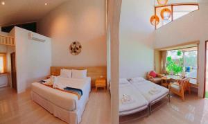 a bedroom with two beds and a living room at Simada Resort&Cafe - สิมาดา สิชล in Ban Plai Thon