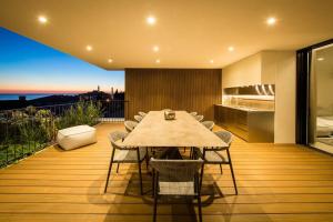 a dining table and chairs on a deck with a kitchen at Z6 Dolcevita Signature - Villa & Private Yacht in the Heart of Rovinj in Rovinj