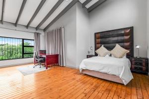 a bedroom with a bed and a desk and a table at Fair Glen in Kyalami +150 photos