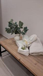 a wooden table with towels and a vase with a plant at Miro B&B in Lecce +246 photos