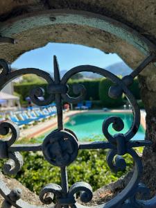 a view of a pool through a wrought iron fence at Villa Volpes con piscina Privata a uso esclusivo tra Versilia e Cinque Terre in Luni