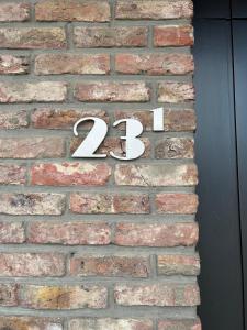 a brick wall with a number on it at Steves Place Haasdonk in Beveren