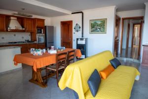 a living room with a yellow couch and a table at House Gennauara in Lanusei +41 photos