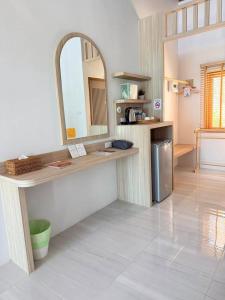 a kitchen with a counter with a mirror and a sink at Simada Resort&Cafe - สิมาดา สิชล in Ban Plai Thon