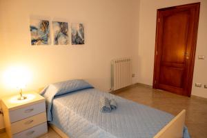 a bedroom with a bed and a dresser with a lamp at House Gennauara in Lanusei