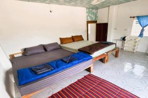 a large bed in a room with a blue couch at I Daa Pra-ea Guesthouse in Phra Ae beach