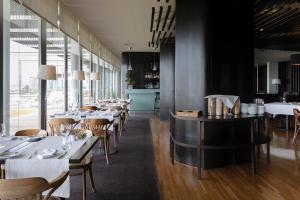 a restaurant with white tables and chairs and windows at Hotel Flor De Sal by The Editory in Viana do Castelo