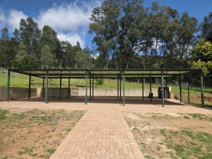 a pavilion in a park with a dog under it at Merino Guest Farm in Clarens