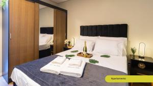 a bedroom with a bed with a bottle of wine on it at Estúdios Completos no Gonzaga com AC, Canal 3, Vila Belmiro, Unifesp in Santos