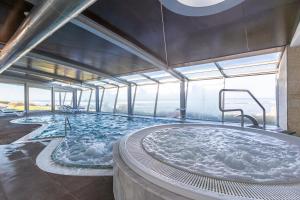 a large hot tub in a building with windows at Hotel Flor De Sal by The Editory in Viana do Castelo