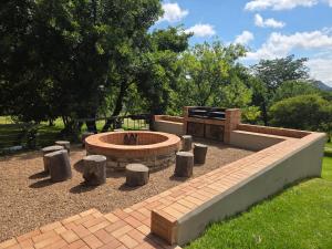 a fire pit in a park with trees and grass at Merino Guest Farm in Clarens