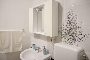 a white bathroom with a toilet and a sink at Home's Vita in Trapani