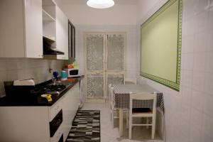 a kitchen with a sink and a table in it at Home's Vita in Trapani