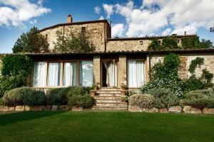 an old stone house with a green lawn at Castello Di Vicarello in Sasso dʼOmbrone