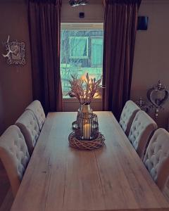a dining room table with a vase of flowers on it at Buktarommet in Alta