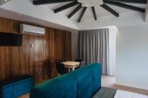 a living room with a blue couch and a table at Os Ninhos dos Avôs in Ponta Delgada