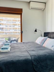 a bedroom with a bed and a table and a window at Apartman Ana Lux in Podgorica