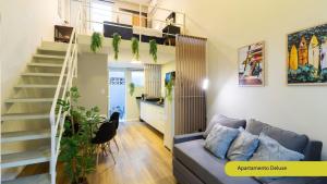 a living room with a staircase and a couch at Estúdios Completos no Gonzaga com AC, Canal 3, Vila Belmiro, Unifesp in Santos