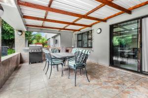 a patio with a table and chairs and a grill at Fair Glen in Kyalami