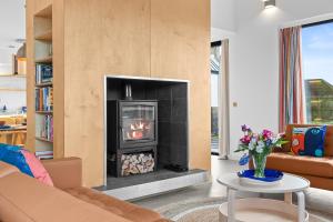 a living room with a fireplace and a couch at An Teallach in Balmullo