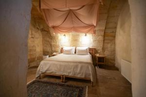 a bedroom with a large bed in a stone room at Urgup Konak Hotel in Ürgüp