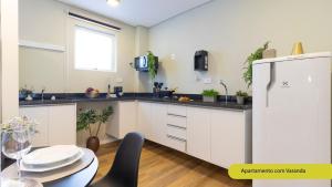 a kitchen with a white refrigerator and a table at Estúdios Completos no Gonzaga com AC, Canal 3, Vila Belmiro, Unifesp in Santos +77 photos