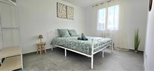 a white room with a bed and a window at Le Freneusien, Wi-Fi parking in Freneuse