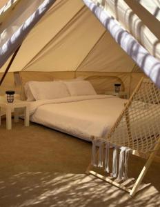 a bed in a tent in a room at Royal desert camp in Al Raka