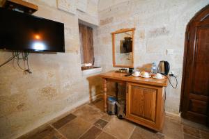 a room with a wooden table and a television on a wall at Urgup Konak Hotel in Ürgüp
