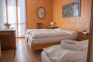 ein Schlafzimmer mit drei Betten und einem Spiegel in der Unterkunft Hotel Cristallo in Folgaria