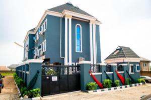 a blue house with a black gate at Dopad Hills Hotel and Suites in Ojo