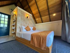 a bedroom with a bed in a room with wooden ceilings at Bluefield Cabana in Ramboda