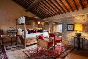 a bedroom with a canopy bed with red pillows at Castello Di Vicarello in Sasso dʼOmbrone +145 photos