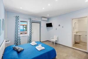 a bedroom with a blue bed with towels on it at La Fiesta House in Capaccio-Paestum