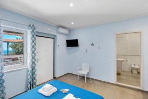 a blue room with a bed and a bathroom at La Fiesta House in Capaccio-Paestum +32 photos