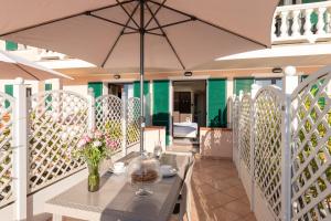 a patio with a table and an umbrella at Del Prado in Riva Ligure